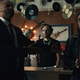 Shadow and Wednesday robbing a music shop by pretending to be an FBI agent and a con man pretending to be a bishop.